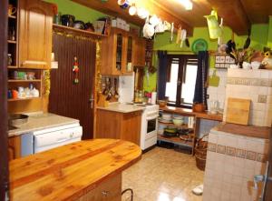 a kitchen with wooden cabinets and a wooden table at Chalupa Dubková in Štôla