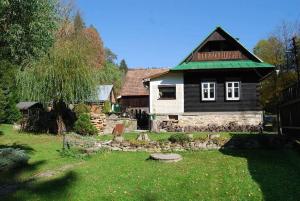 una pequeña casa con un techo verde en un patio en Chalupa Dubková, en Lazy pod Makytou