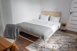 uma cama com lençóis brancos e almofadas num quarto em Apartament AUGUSTYN em Ostrów Wielkopolski
