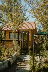 a small house with a metal roof and a porch at Rivel land in Tsʼkhmorisi