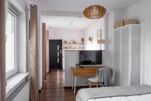 Schlafzimmer mit einem Bett und einem Schreibtisch mit einem TV in der Unterkunft Apartament AUGUSTYN in Ostrowo