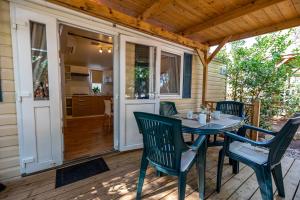 a patio with a table and chairs on a deck at Camping Kozarica Mobile Homes in Pakoštane