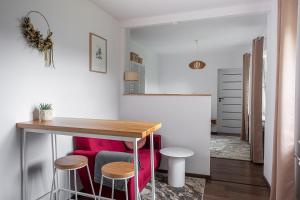 a kitchen with a table and stools in a room at Apartament AUGUSTYN in Ostrów Wielkopolski