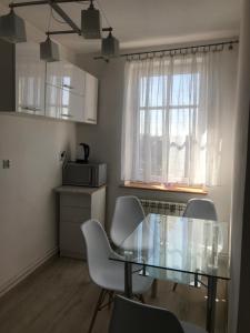 ein Esszimmer mit einem Glastisch und Stühlen in der Unterkunft Apartament Rodzinny S10 in Kalisz