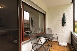 een patio met een tafel en stoelen op een balkon bij Alpenblume in Fischen