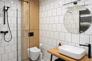 W łazience znajduje się toaleta, umywalka i lustro. w obiekcie Apartament AUGUSTYN w Ostrowie Wielkopolskim