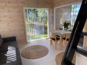 una pequeña sala de estar con mesa y sillas en una cabaña de madera en Villa Varis en Jorvas