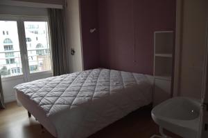 sypialnia z dużym łóżkiem i oknem w obiekcie Valentino 0401 w mieście Koksijde