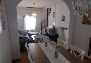 a living room with a table with chairs and a couch at Townhouse Almunecar Old Town in Almuñécar