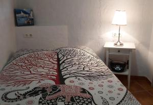 a bed with a blanket with a tree on it at Townhouse Almunecar Old Town in Almuñécar