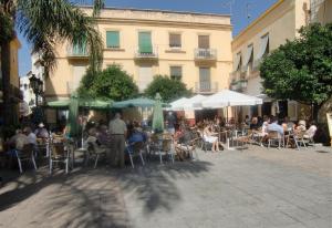 a group of people sitting at tables and chairs at Townhouse Almunecar Old Town in Almuñécar