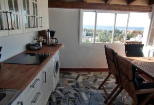 a kitchen with a counter and a table with chairs at Townhouse Almunecar Old Town in Almuñécar