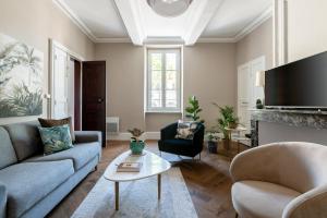 a living room with two couches and a tv at Maison d'hôtes ÔVillage in Ouveillan