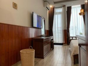 Pokój z telewizorem, łóżkiem i komodą w obiekcie Hào Hoa Hotel Kon Tum w mieście Kon Tum