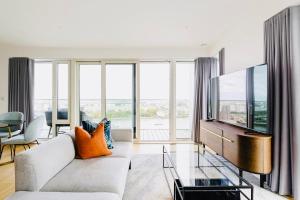 a living room with a couch and a tv at Executive Waterfront Split Penthouse in Woolwich