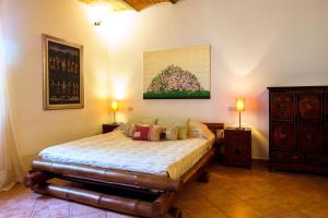 a bedroom with a bed and a painting on the wall at Agriturismo Cavalierino in Montepulciano +60 photos