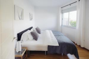 a white bedroom with a bed and a window at Cornisa Apartments in Patalavaca