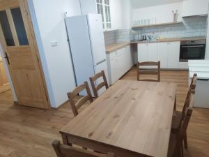 cocina con mesa de madera y sillas en Apartmán Poštolka, en Branná