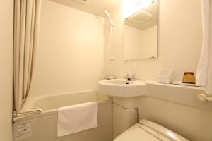 a white bathroom with a sink and a toilet at KOKO HOTEL Osaka Namba Ebisucho in Osaka +32 photos