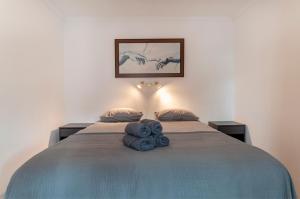 sypialnia z łóżkiem, na którym leżą dwa niebieskie ręczniki w obiekcie One bedroom apartment with sea views Marbella heart w Marbelli