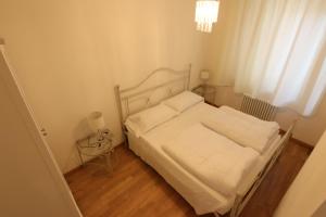 a small bedroom with a white bed and a window at charmante apartament lake front in Malcesine