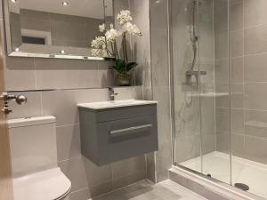 een badkamer met een douche, een toilet en een wastafel bij Exclusive Cardiff City Centre Apartment in Cardiff