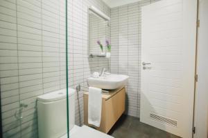 a bathroom with a sink and a toilet and a mirror at Cornisa Apartments in Patalavaca