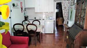 a kitchen and dining room with a table and a red couch at Casa BENVINDHA in Degolados