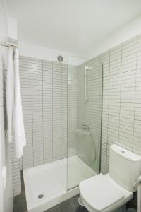 a white bathroom with a shower and a toilet at Cornisa Apartments in Patalavaca
