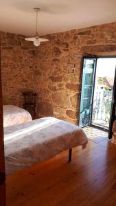 a bedroom with a bed and a stone wall at Casa dos Castaños in O Grove