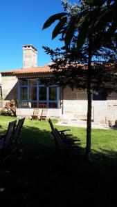 a group of chairs sitting in the grass in front of a house at Casa dos Castaños in O Grove