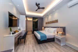 a hotel room with a bed and a desk and a chair at Sky Beach Maldives - Dhiffushi in Dhiffushi +58 photos