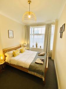 Un dormitorio con una cama y una ventana grande. en Heart of Hastings Historic Old Town, en Hastings