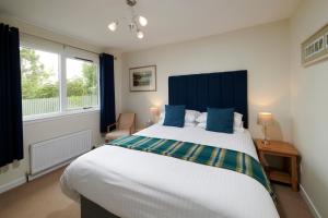 een slaapkamer met een groot bed met een blauw hoofdeinde bij By the Brae in Inverness