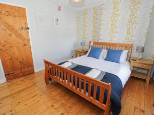 a bedroom with a wooden bed with blue pillows at Tryfan in Caernarfon