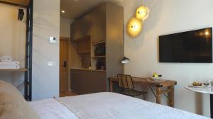 sypialnia z łóżkiem, stołem i telewizorem w obiekcie San Jorge Suites Triana w Sewilli +29 zdjęć