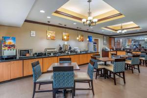 a restaurant with tables and chairs and a counter at Comfort Suites in Vicksburg