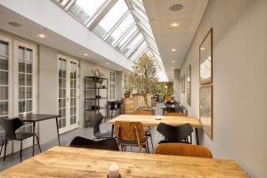 a dining room with tables and chairs and a skylight at Skarrildhus Sinatur Hotel & Konference in Skarrild