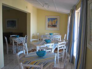 a dining room with tables and chairs with blue bowls on them at Oceanview Umkomaas in Umkomaas