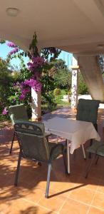a table and chairs on a patio with purple flowers at Apartments Golić in Biograd na Moru