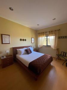 a bedroom with a large bed and a window at Casa da Quinta in Tabuaço