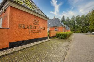 a building with a sign on the side of it at Skarrildhus Sinatur Hotel & Konference in Skarrild