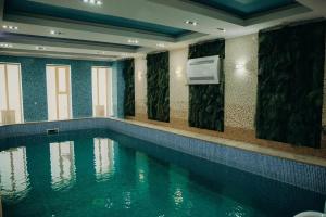 a swimming pool with a television in a building at Gostinichnyy Kompleks Tobol in Kostanay
