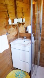 La salle de bains est pourvue d'un lavabo blanc et d'une douche. dans l'établissement Casa Margarida, Quinta Carmo - Alcobaça - Nazaré, à Alcobaça