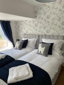 two beds sitting next to each other in a bedroom at Naze View Barn - Cosy, with all mod cons in Whaley Bridge