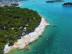 - une vue aérienne sur une plage avec des personnes dans l'eau dans l'établissement Kozarica Apartments, à Pakoštane