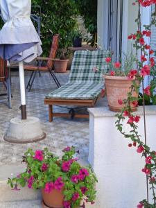 a patio with potted plants and a bench and flowers at Apartments Blazenka in Trogir