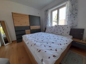 ein Schlafzimmer mit einem Bett mit einer Tagesdecke mit Schmetterlingen darauf in der Unterkunft Ferienhaus Angel in Weitra
