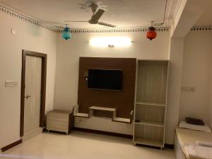 uma sala de estar com uma televisão de ecrã plano na parede em Full View Villa em Udaipur