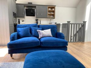 a blue couch sitting in a living room at Naze View Barn - Cosy, with all mod cons in Whaley Bridge